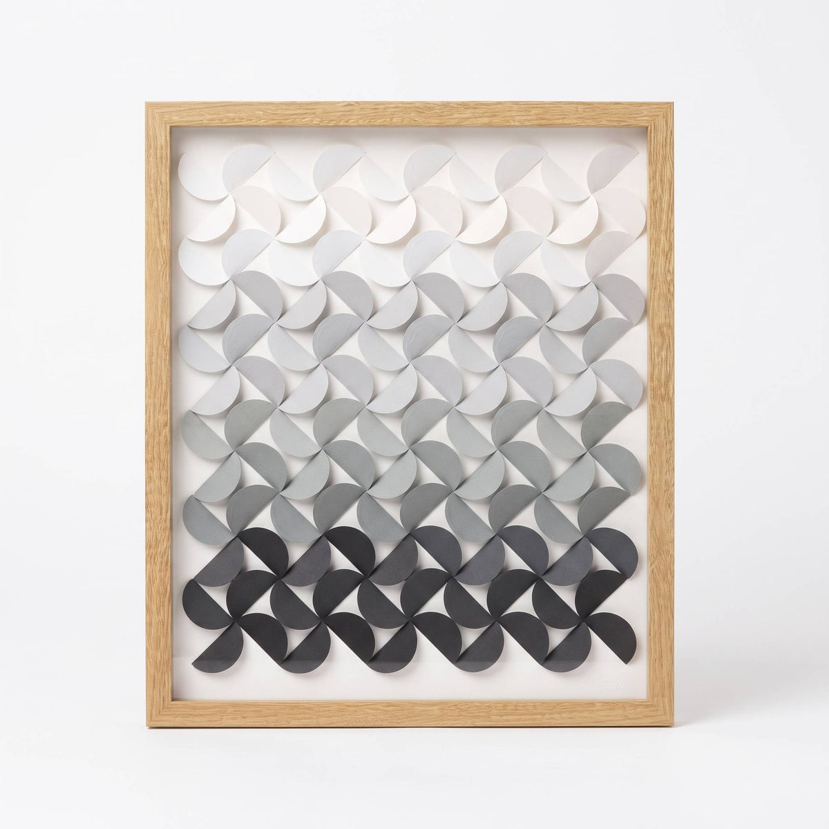 Cuadro Arco Vivo Ceniza: origami modular en degradado de blanco a gris oscuro, con marco de madera