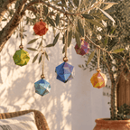 Esferas de origami de colores colgadas de un olivo al aire libre