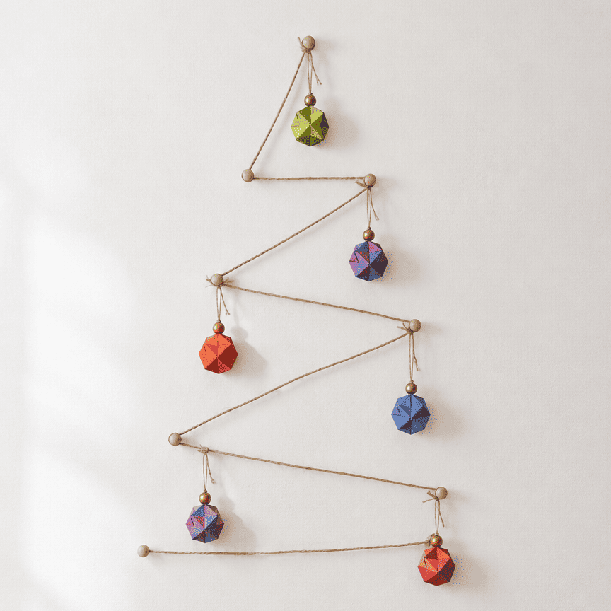 Árbol de Navidad minimalista hecho con cordel en zigzag y esferas de origami de colores colgadas en la pared