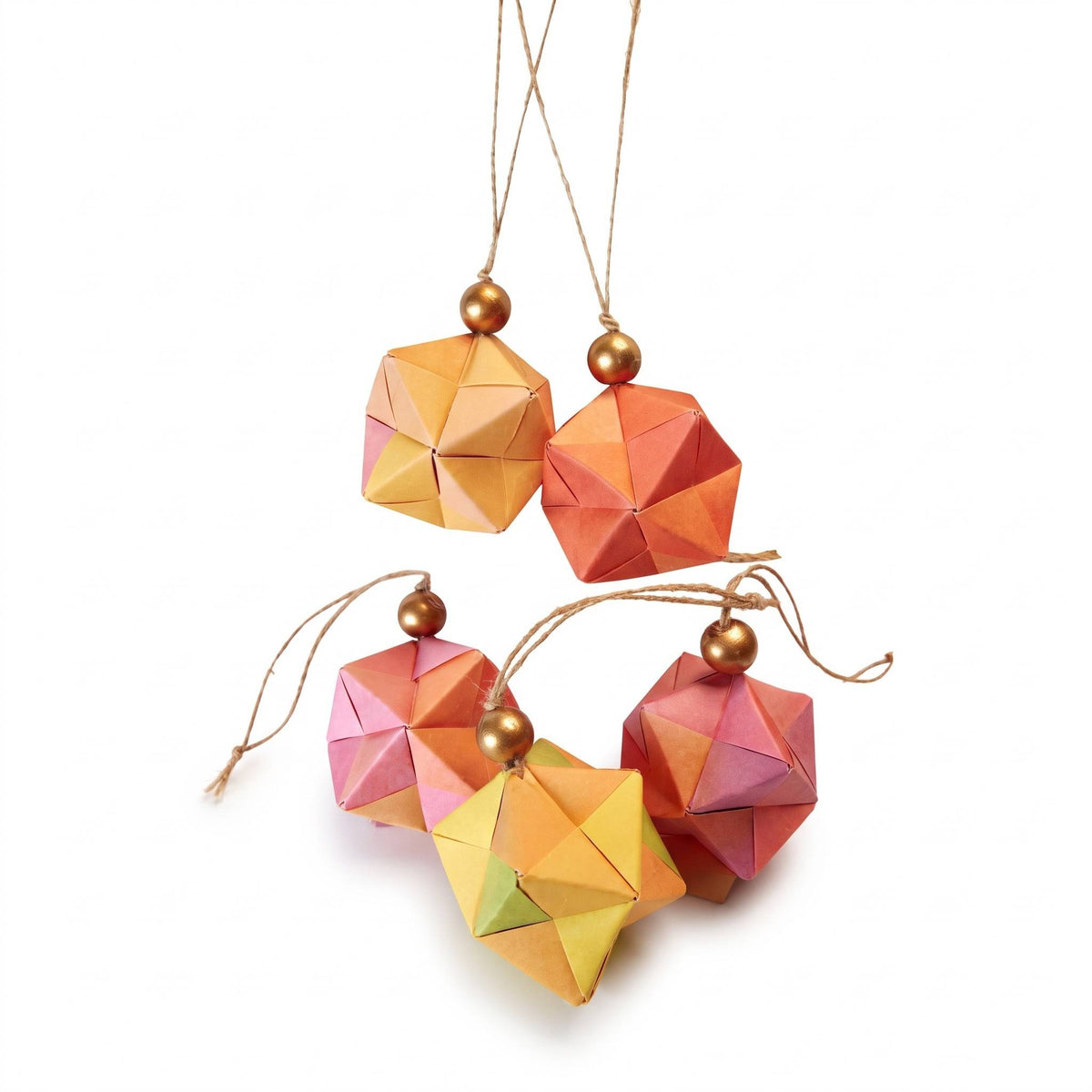 Esferas de origami naranjas, rosas y amarillas colgadas de cordeles